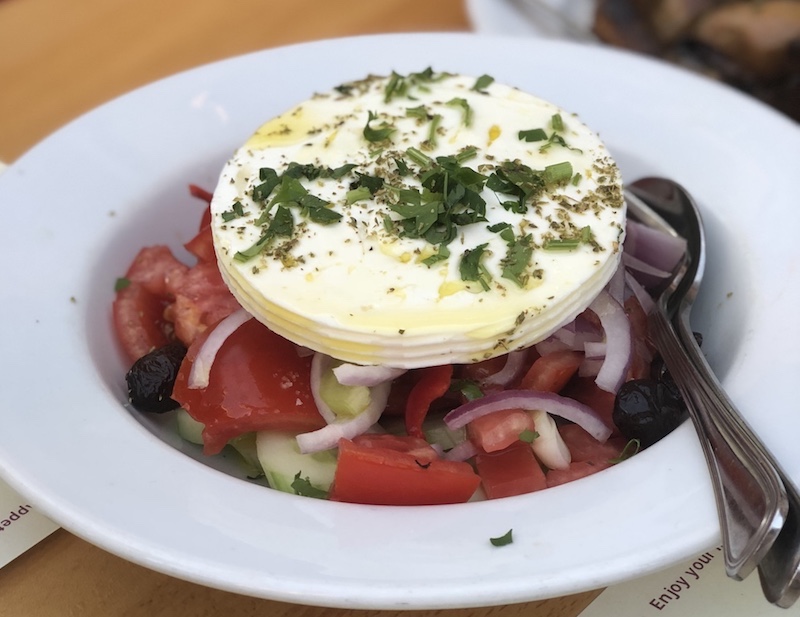 Greek salad - Yunan Salatası üzerinde koca bir dilim beyaz peynir ile servis ediliyor.